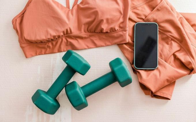 Roupa esportiva, halteres e smartphone Flatlay