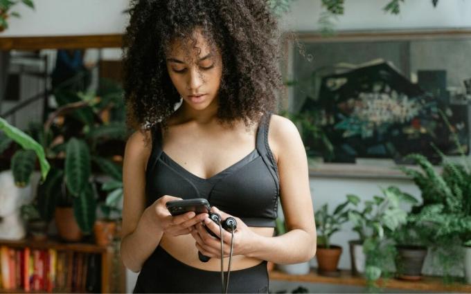 Mulher segurando um telefone celular e pular corda