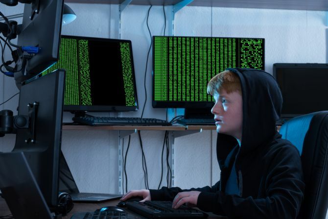 hacker adolescente usando vários computadores