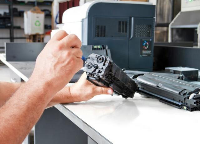 Mãos reparando o cartucho de toner laser