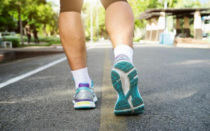 Pés de atleta corredor correndo na estrada