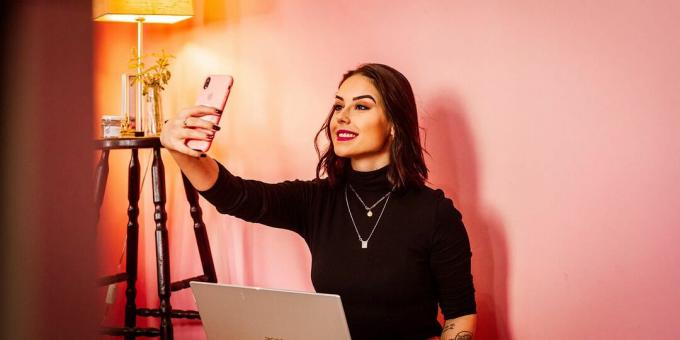 Mulher tirando uma selfie no quarto