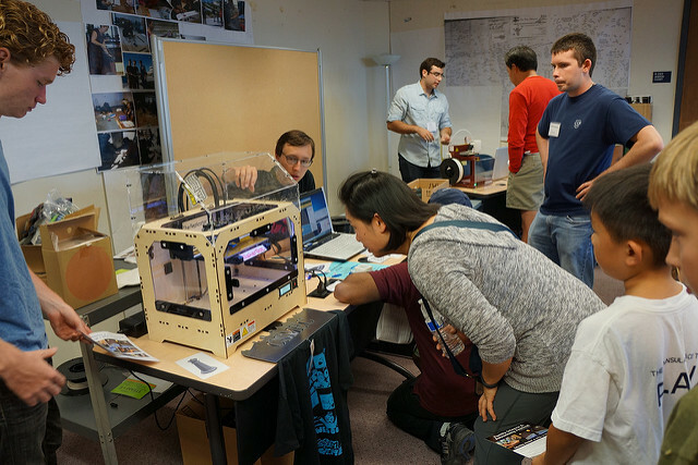 pessoas olhando para impressora 3d