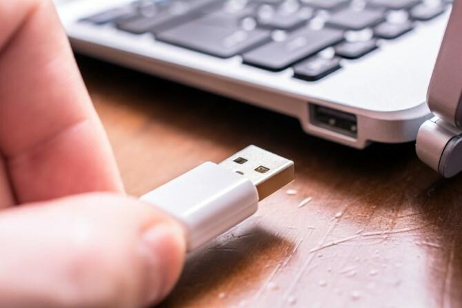 Homem desconectando o dispositivo USB do computador